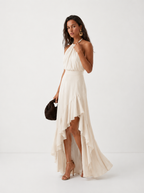 Elegante vestido de invitada de boda con cuello halter y bajo asimétrico de volantes