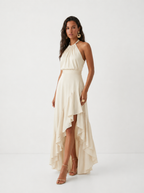 Elegante vestido de invitada de boda con cuello halter y bajo asimétrico de volantes