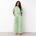 Elegante conjunto de mujer de dos piezas de invitada de boda con calado floral y pantalón fluido